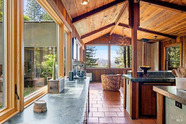 sunroom with a notable chandelier and beamed ceiling