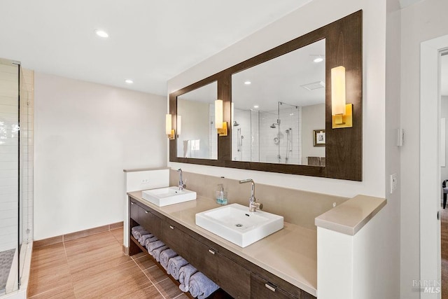 bathroom featuring recessed lighting, a sink, and a stall shower