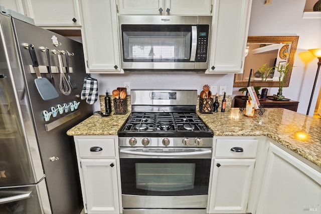kitchen featuring white cabinets, light stone countertops, and stainless steel appliances