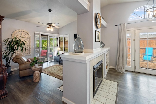 kitchen with wood finished floors, plenty of natural light, ceiling fan with notable chandelier, and lofted ceiling