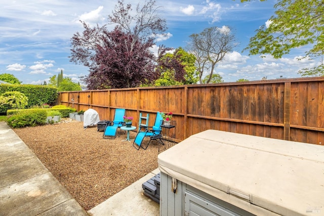 view of yard with a fenced backyard, a hot tub, and a patio area
