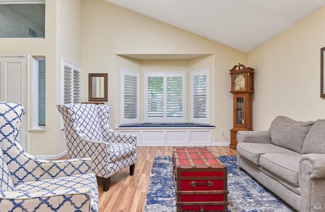 living room with wood finished floors, vaulted ceiling, and baseboards