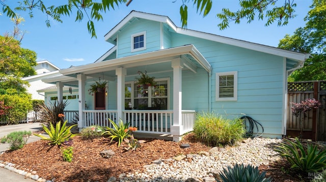 view of front facade featuring fence and covered porch