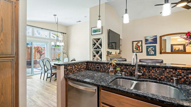 kitchen with a sink, dishwasher, dark stone countertops, light wood-type flooring, and visible vents