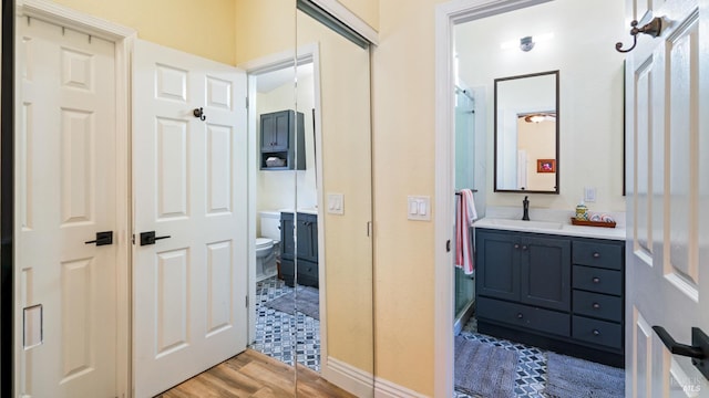 full bathroom with toilet, wood finished floors, and vanity