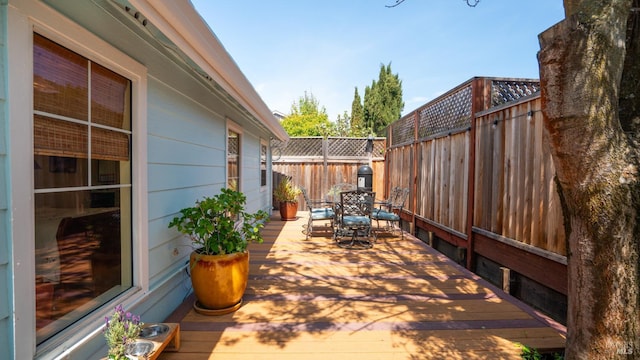 wooden terrace featuring fence and outdoor dining area
