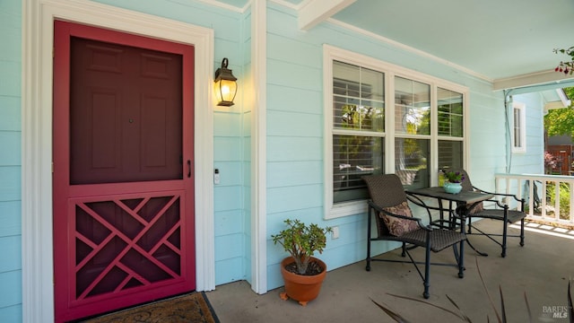 view of exterior entry with covered porch