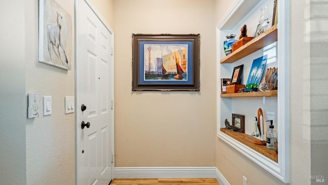 doorway to outside with baseboards and wood finished floors