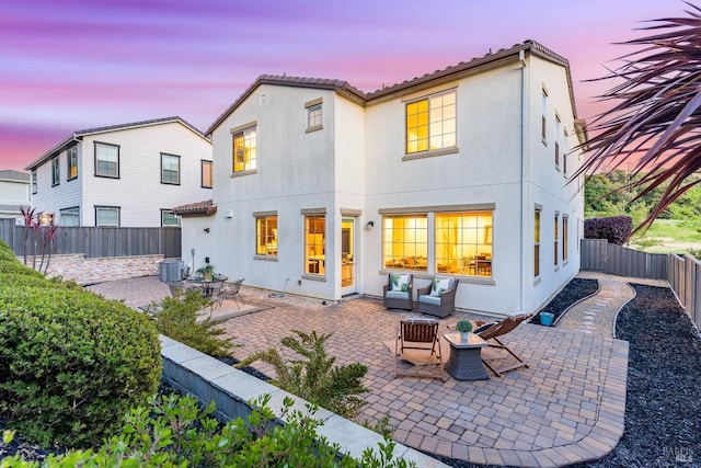 rear view of property with central AC, stucco siding, outdoor lounge area, a fenced backyard, and a patio