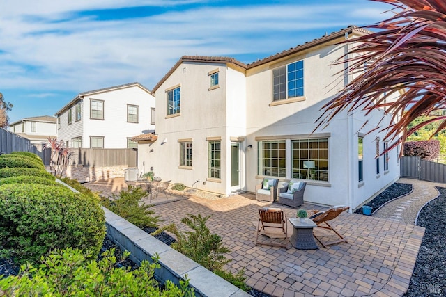 back of property featuring cooling unit, a fenced backyard, a patio, outdoor lounge area, and stucco siding