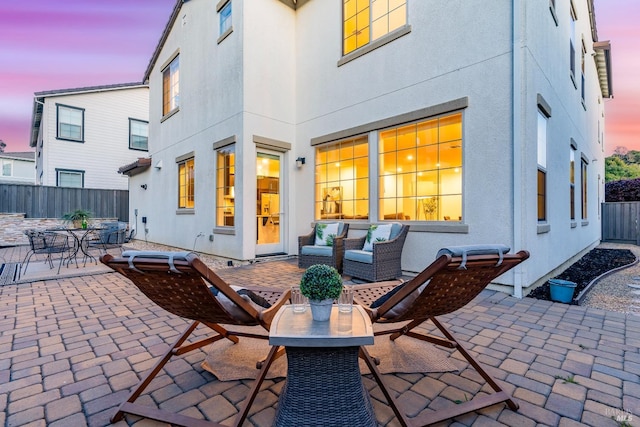 exterior space featuring fence, outdoor dining area, a patio, and stucco siding