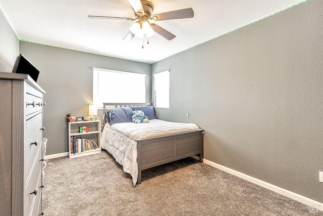 carpeted bedroom with a ceiling fan, baseboards, and a textured wall