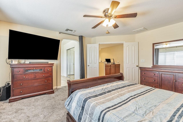 bedroom featuring arched walkways, carpet, a ceiling fan, and visible vents
