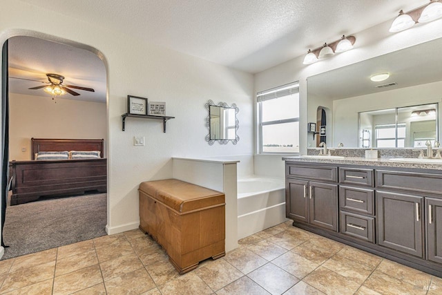 bathroom featuring connected bathroom, a ceiling fan, a sink, and a bath
