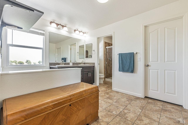 bathroom featuring a stall shower, tile patterned floors, vanity, baseboards, and toilet