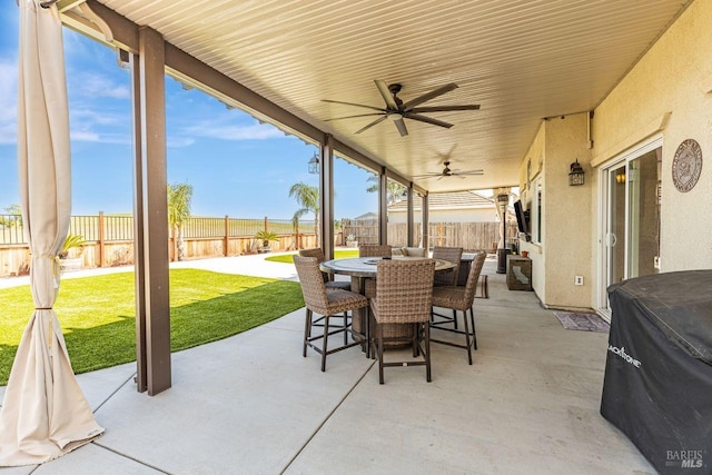 view of patio with outdoor dining area, a fenced backyard, and ceiling fan