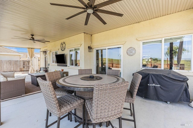 view of patio featuring area for grilling, ceiling fan, fence, and outdoor dining area