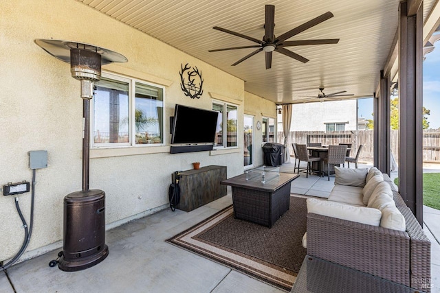 view of patio / terrace with ceiling fan, fence, an outdoor hangout area, and outdoor dining space