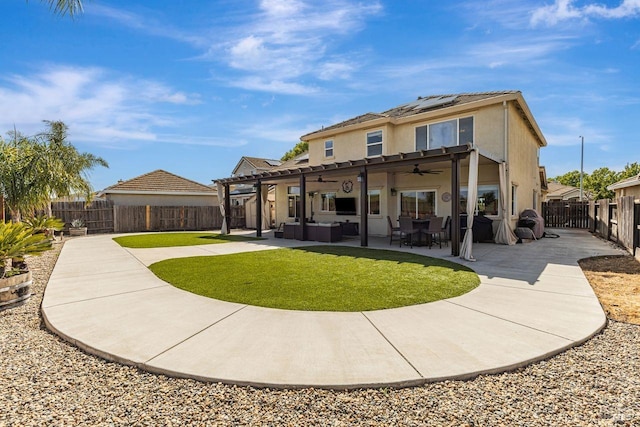 rear view of property with ceiling fan, outdoor lounge area, a fenced backyard, stucco siding, and roof mounted solar panels