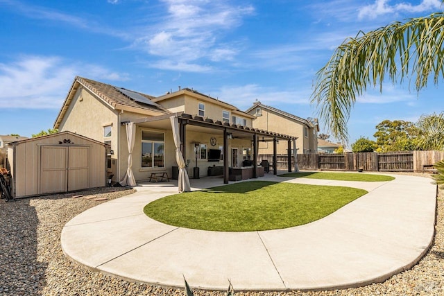 back of house featuring a storage shed, an outbuilding, a patio area, a fenced backyard, and stucco siding