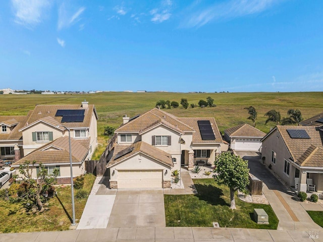 view of front of home featuring fence, stucco siding, driveway, and solar panels