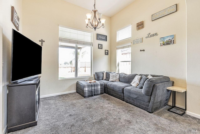 living area featuring carpet floors, baseboards, a high ceiling, and a chandelier
