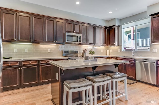 218 Johnson St, Windsor, CA 95492 - kitchen with stainless steel appliances, a sink, a kitchen bar, decorative backsplash, and a kitchen island