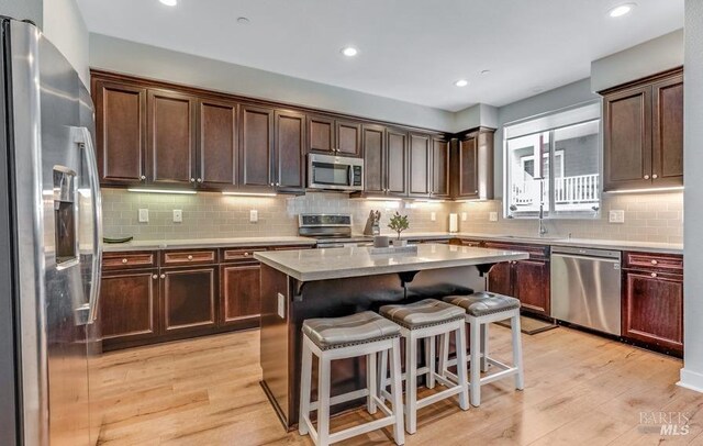 218 Johnson St, Windsor, CA 95492 - kitchen with stainless steel appliances, a sink, a breakfast bar area, tasteful backsplash, and light countertops