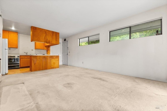 105 Virginia Ave Unit 2, Sebastopol, CA 95472 - kitchen with freestanding refrigerator, brown cabinets, light countertops, and light colored carpet
