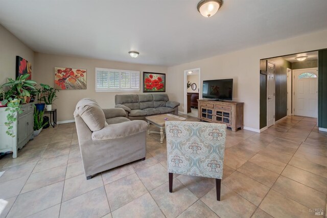 living area featuring baseboards and light tile patterned flooring