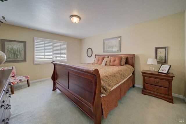 bedroom with baseboards and light carpet