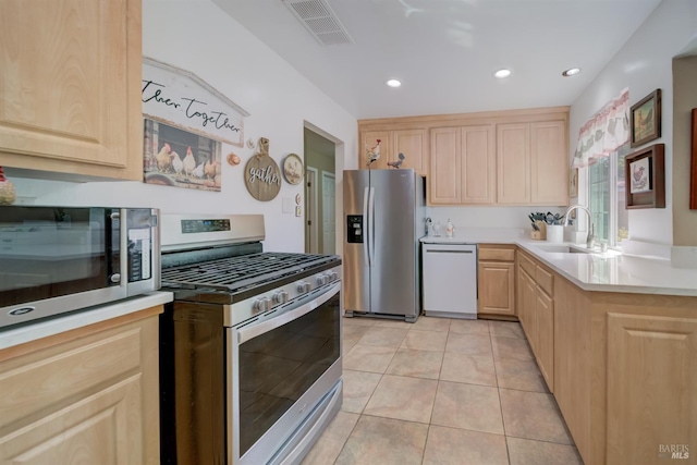 kitchen featuring visible vents, light brown cabinetry, light countertops, a sink, and stainless steel appliances