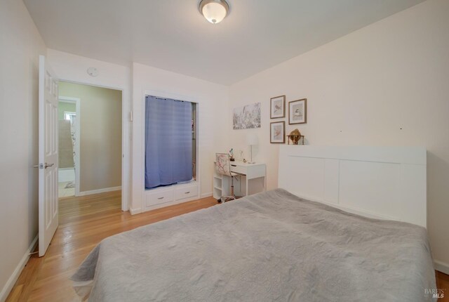 bedroom with baseboards and wood finished floors