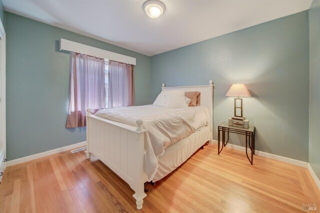 bedroom featuring baseboards and light wood-type flooring