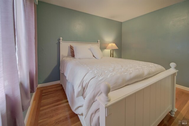 bedroom with baseboards and wood finished floors