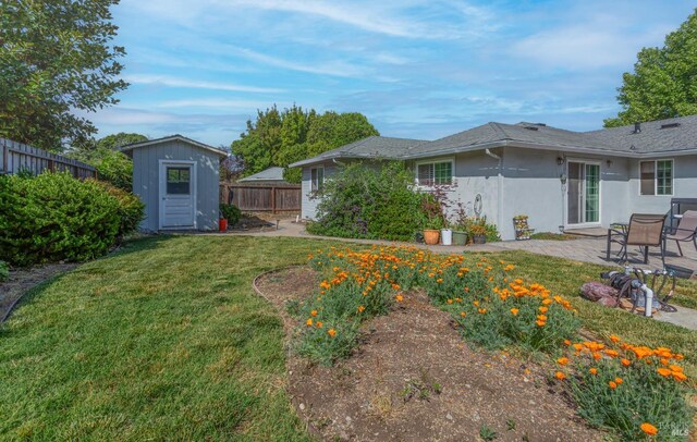 view of yard featuring an outdoor structure, a shed, a fenced backyard, and a patio area