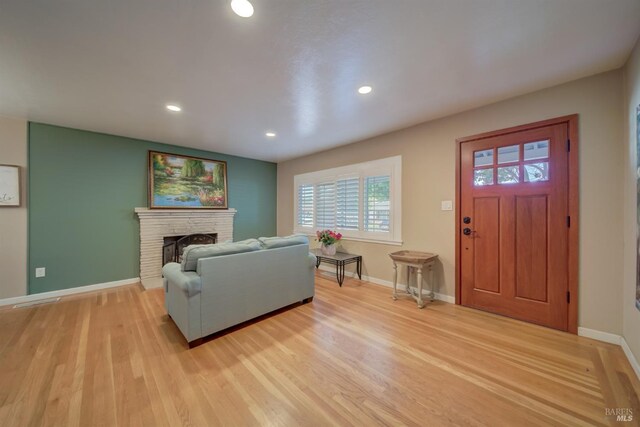 living room featuring recessed lighting, baseboards, and light wood finished floors