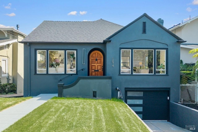 view of front of house featuring a garage, fence, stucco siding, and a front yard