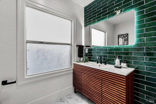 bathroom with tile walls, marble finish floor, and vanity