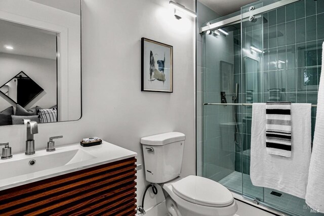 bathroom featuring vanity, a stall shower, and toilet