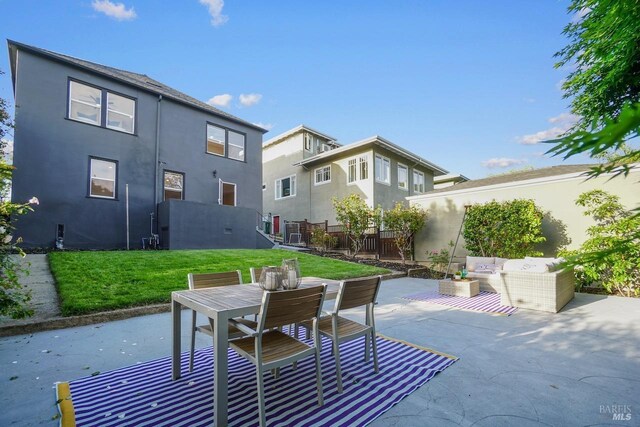 back of property with fence, an outdoor hangout area, stucco siding, a patio area, and a lawn