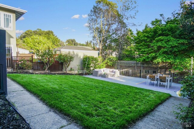 view of yard featuring a patio, an outdoor living space, and a fenced backyard