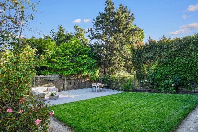 view of yard featuring a patio, outdoor lounge area, and fence
