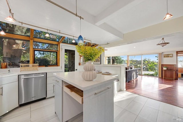kitchen with stainless steel dishwasher, beam ceiling, light countertops, a sink, and white cabinetry