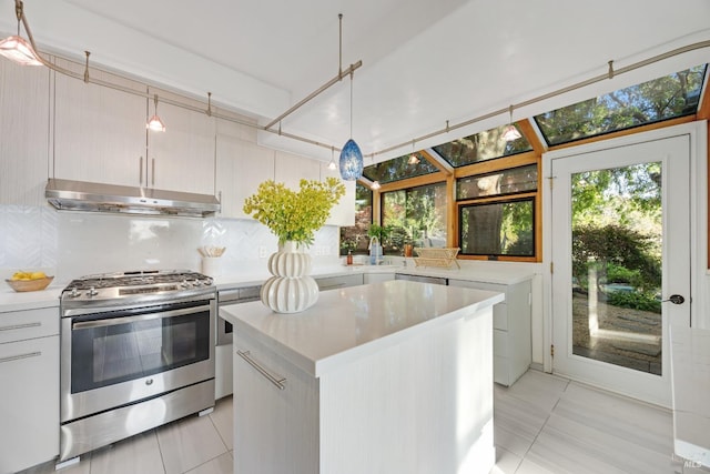 kitchen with under cabinet range hood, light countertops, light tile patterned floors, and gas range