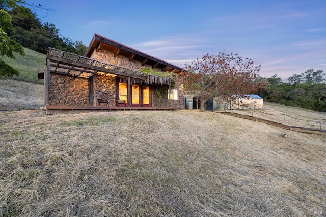 back of house featuring stone siding