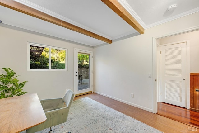 unfurnished office featuring baseboards, beamed ceiling, ornamental molding, and wood finished floors