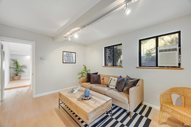 living room with cooling unit, rail lighting, baseboards, and light wood-type flooring
