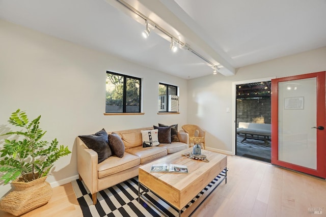 living area with track lighting, light wood-style flooring, and baseboards