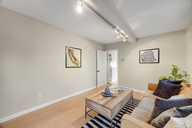 living area with rail lighting, baseboards, and light wood-style floors